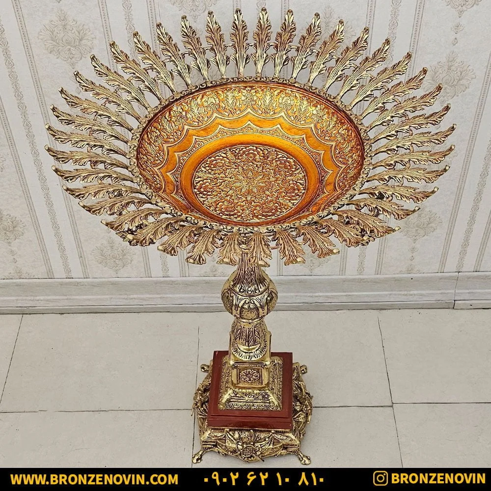 میوه خوری برنجی پایه دار کنار سالنی ایستاده